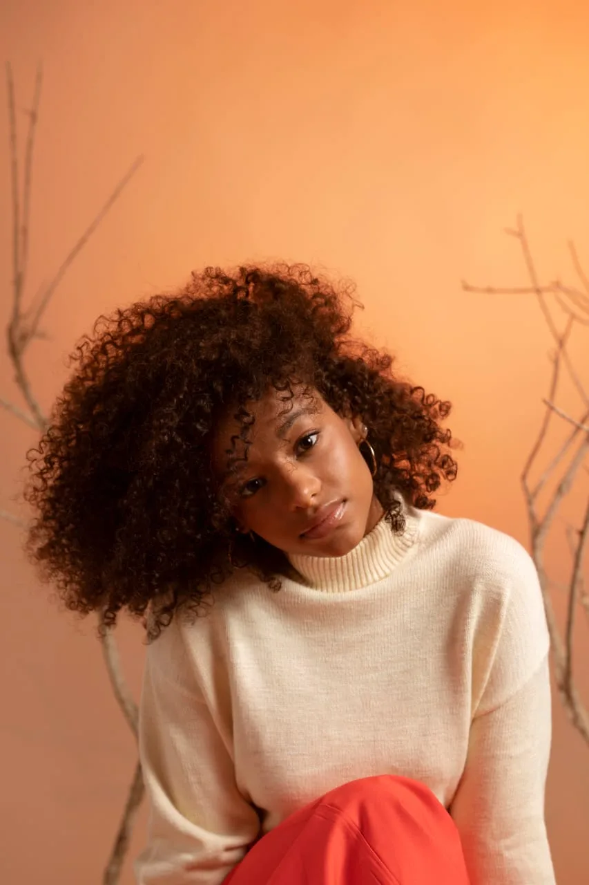 Cheveux crépus soignés, sur fond pêche